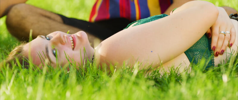 Girl at Lollapalooza Festival laying in grass, smilling, happy