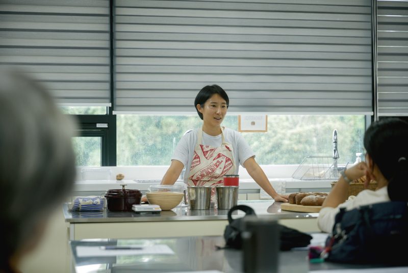 Chef leading a cooking class and explaining techniques to students in a modern kitchen